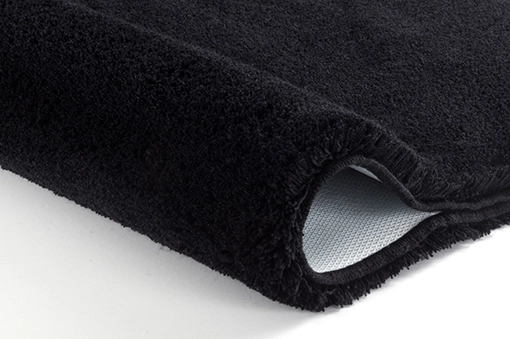 Schwarzer, flauschiger Badteppich mit rutschfester Unterseite, ideal für ein modernes Badezimmer.
