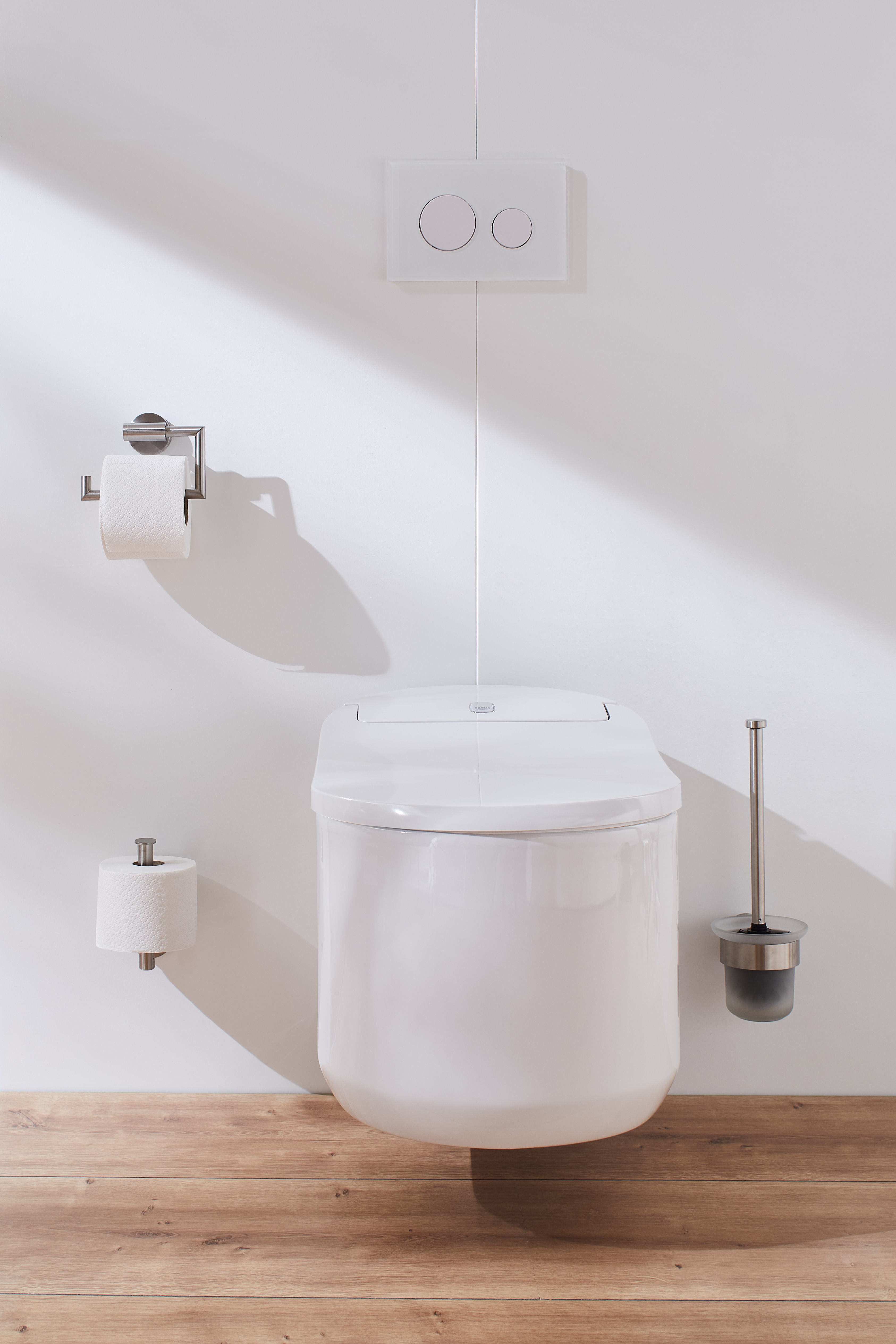 Modernes, wandhängendes WC mit weißer Keramik, integriertem Spülkasten und stilvollem Toilettenpapierhalter in einem hellen Badezimmer.
