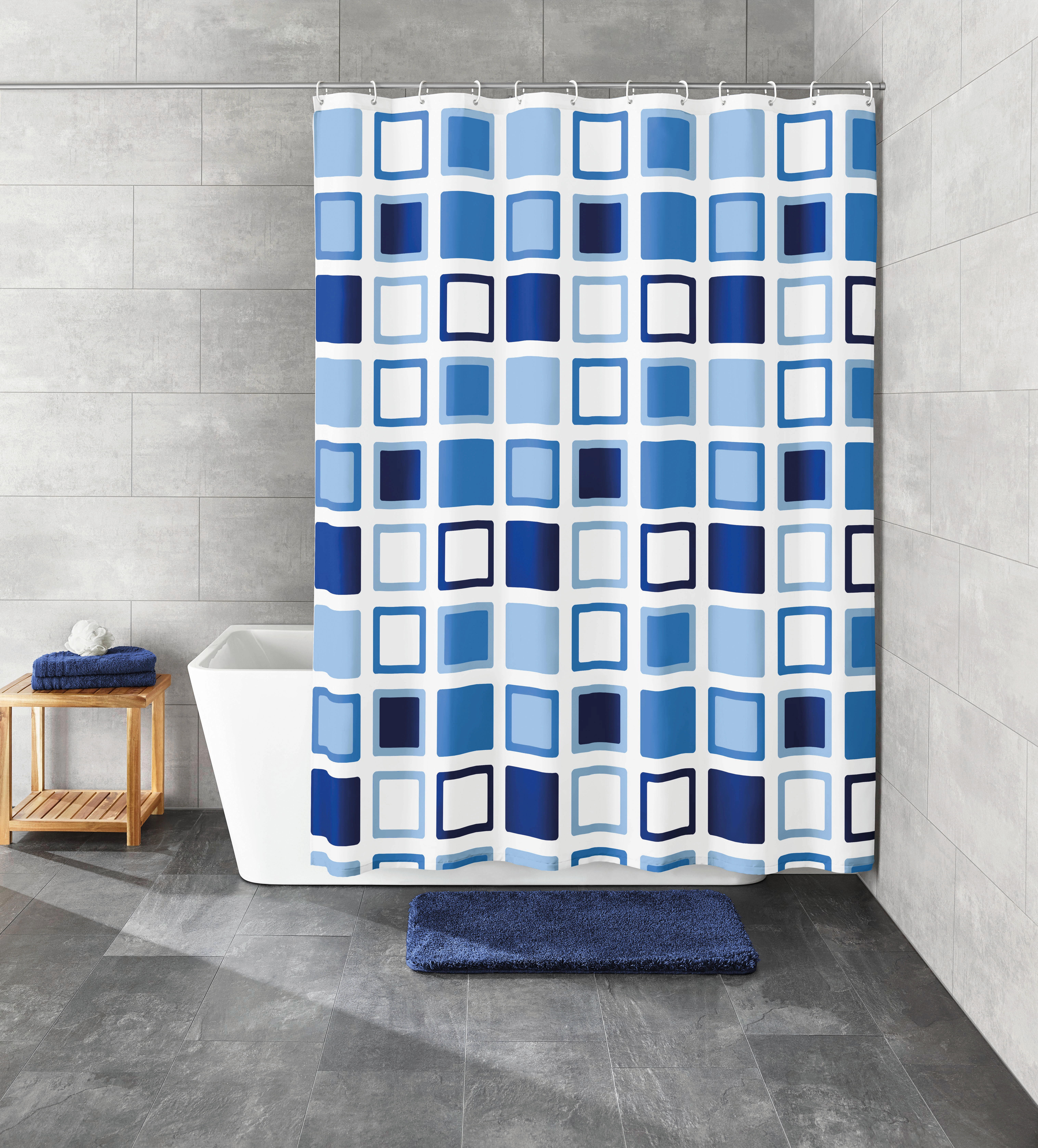 Duschvorhang mit blau-weißem geometrischem Muster, moderne Badezimmerdekoration, passend zu blauen Handtüchern und Badematte.