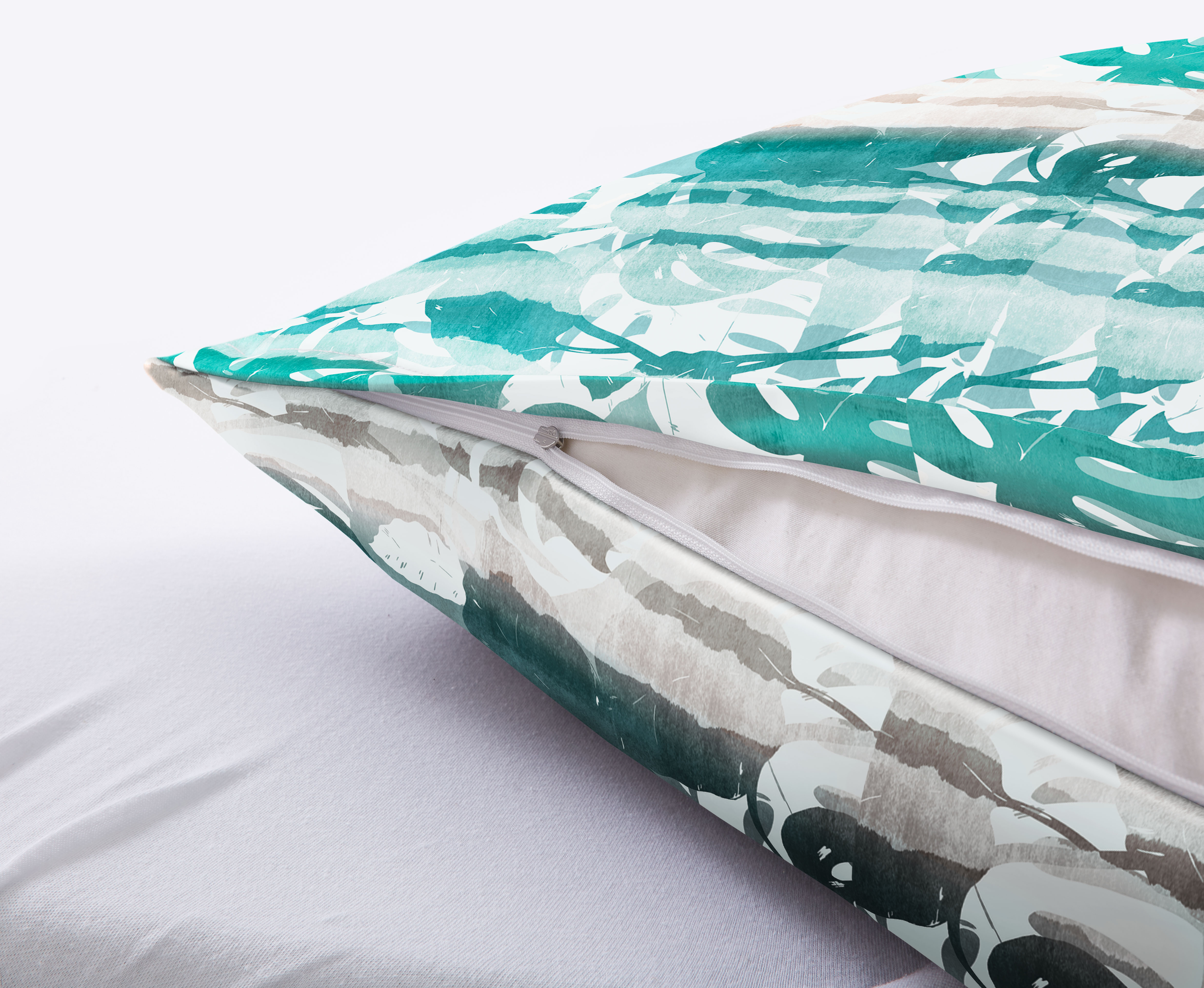 Dekoratives Kissen mit grün-weißem Blattmuster und Reißverschluss, ideal für stilvolle Wohnräume.