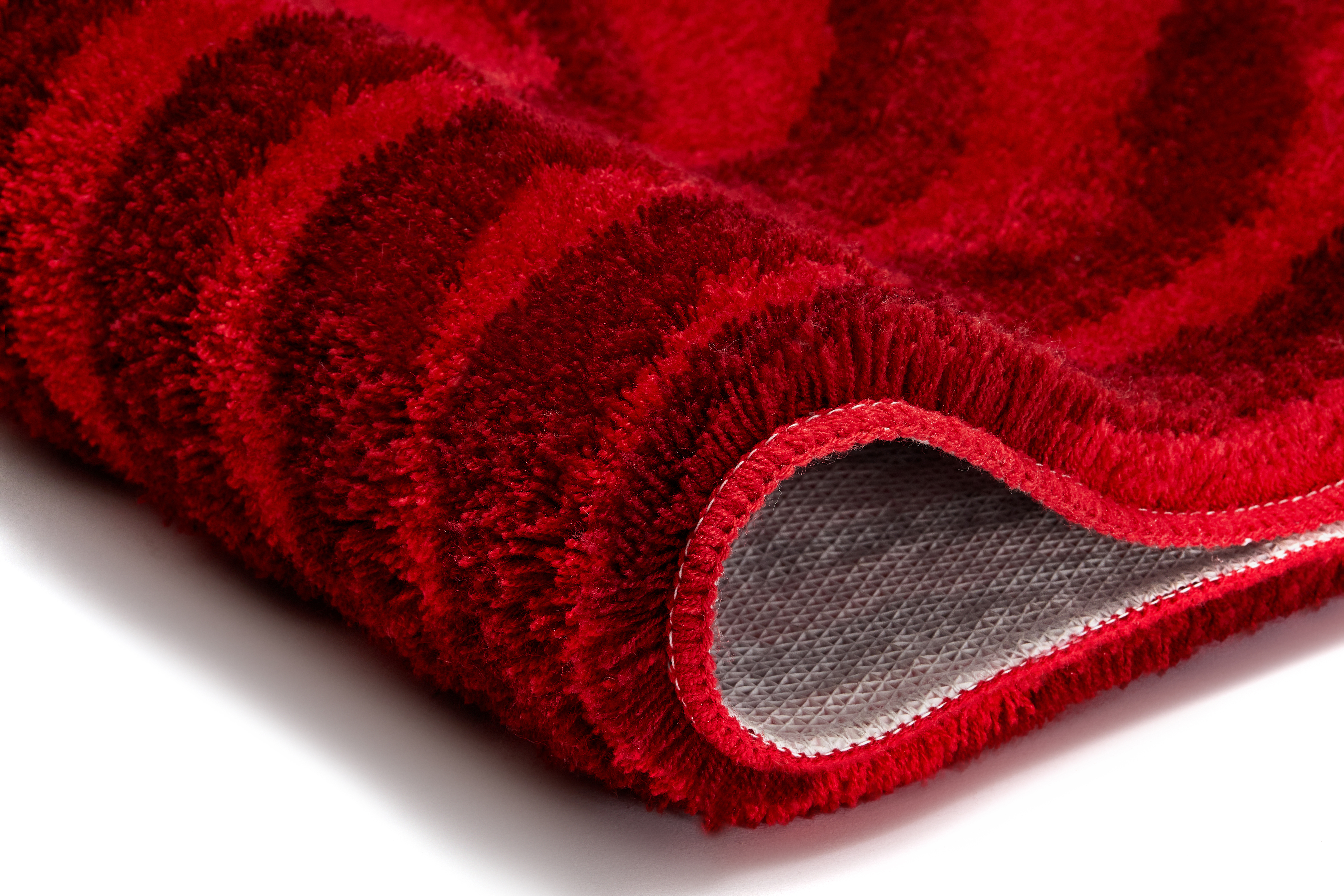 Roter, flauschiger Badteppich mit rutschfester Unterseite und dezentem Streifenmuster. Ideal für ein gemütliches Badezimmer.