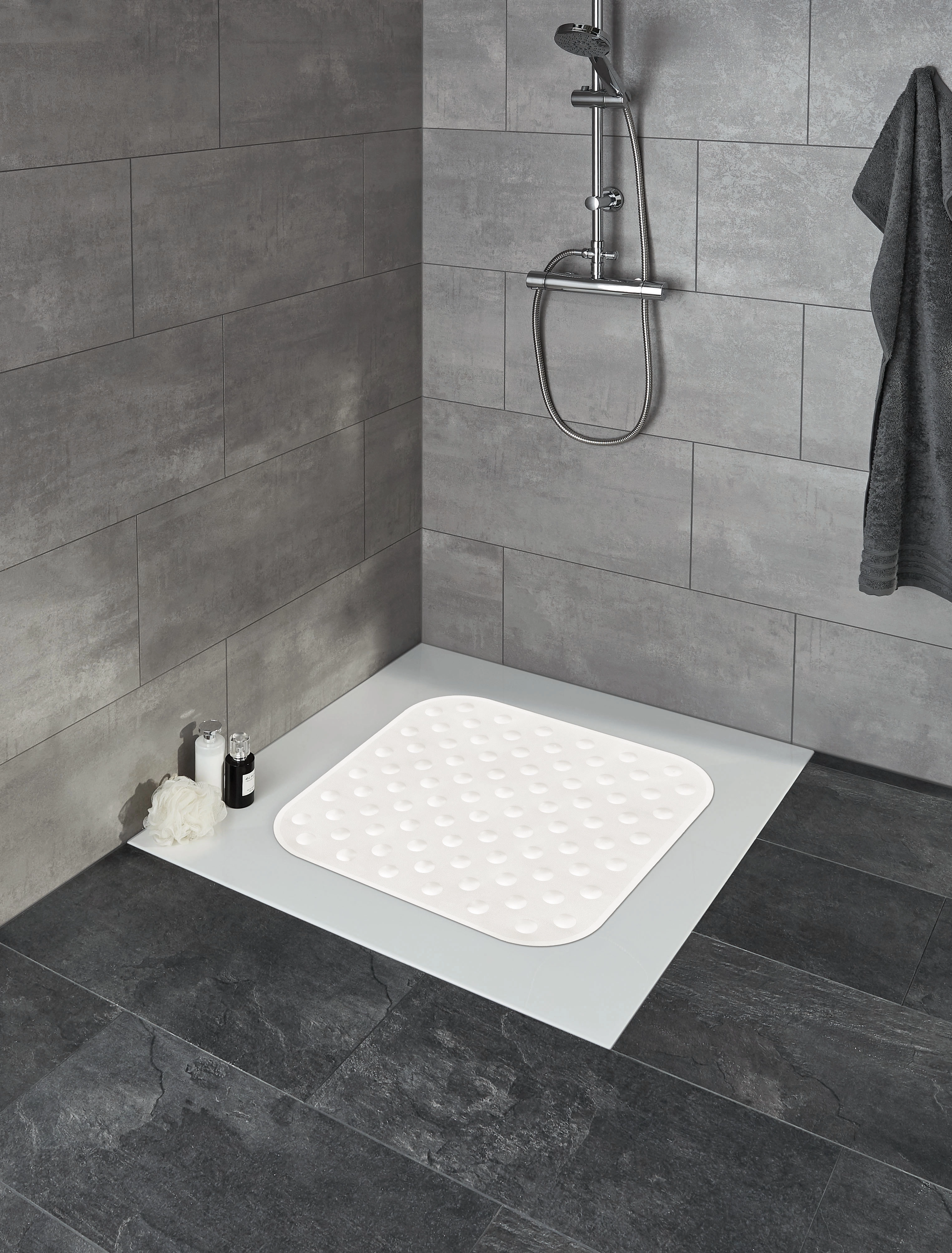 Rutschfeste Duschmatte in modernem Badezimmer mit grauen Fliesen und Duschkopf.